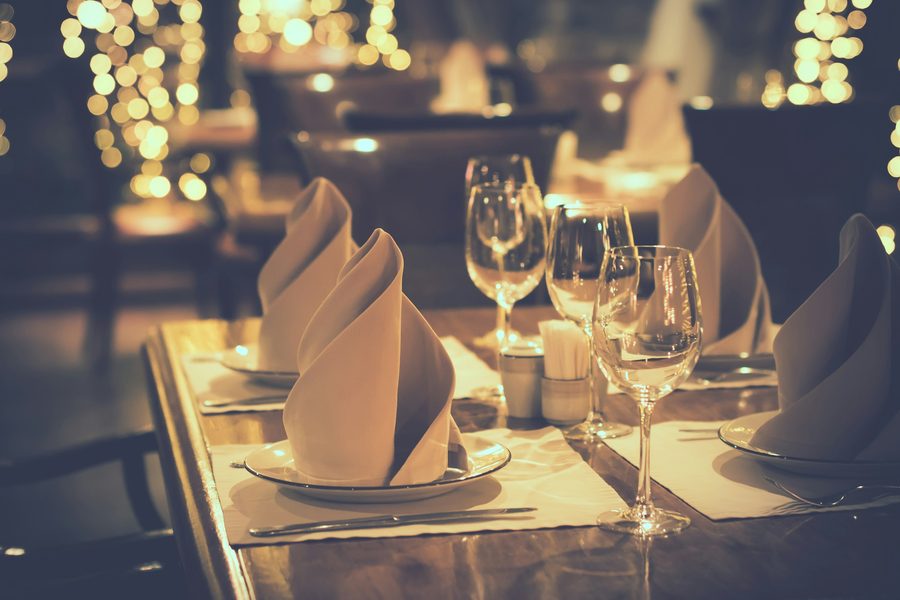 Gedeckter Tisch mit Weingläsern im Kerzenschein
