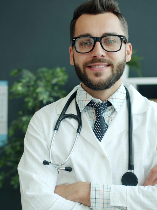 Arzt mit verschränkten Armen im Sprechzimmer