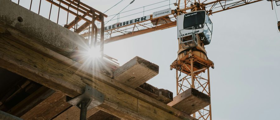 Baustelle mit Schalung und Kran im Gegenlicht