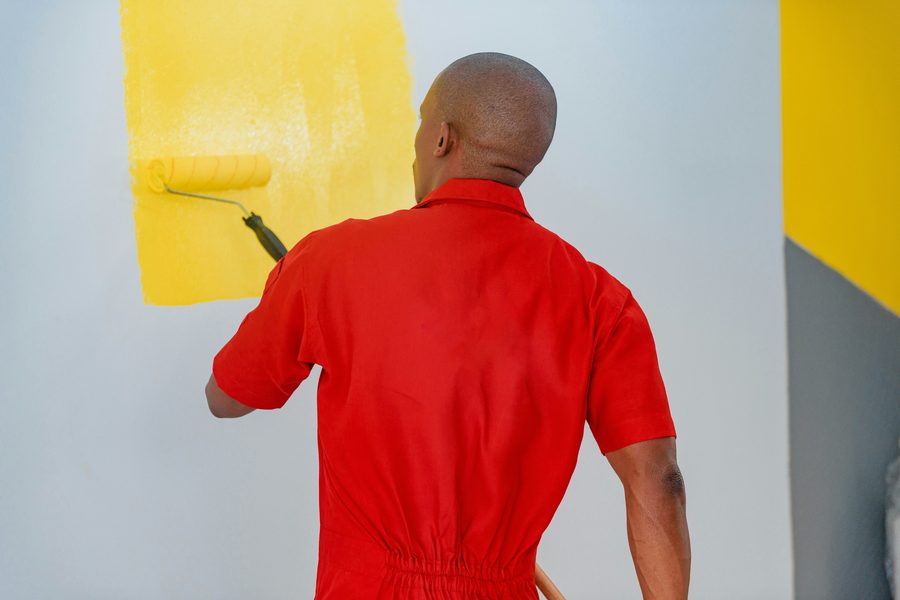Maler mit Farbrolle an der Wand
