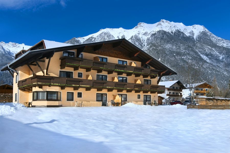 Hotelgebäude im Schnee vor Bergkulisse