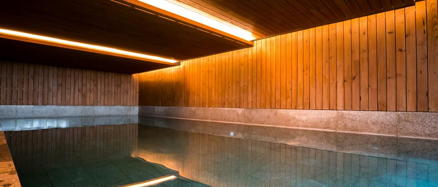 Innenpool mit Holzverkleidung und indirekter Beleuchtung