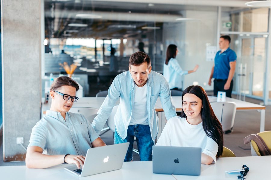 Team bei der gemeinsamen Arbeit an Laptops